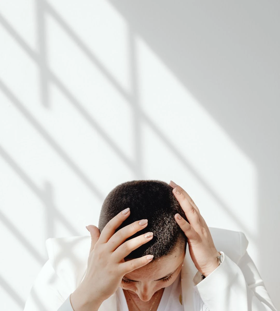 6 zawodów które niszczą życie i szczęście Foto: kobieta trzymająca się za głowę