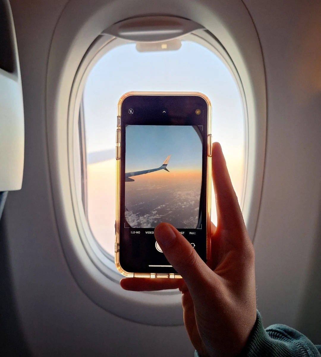 Tanie linie wprowadzają WiFi na pokładzie Foto: ręka trzymająca telefon komórkowy w samolocie